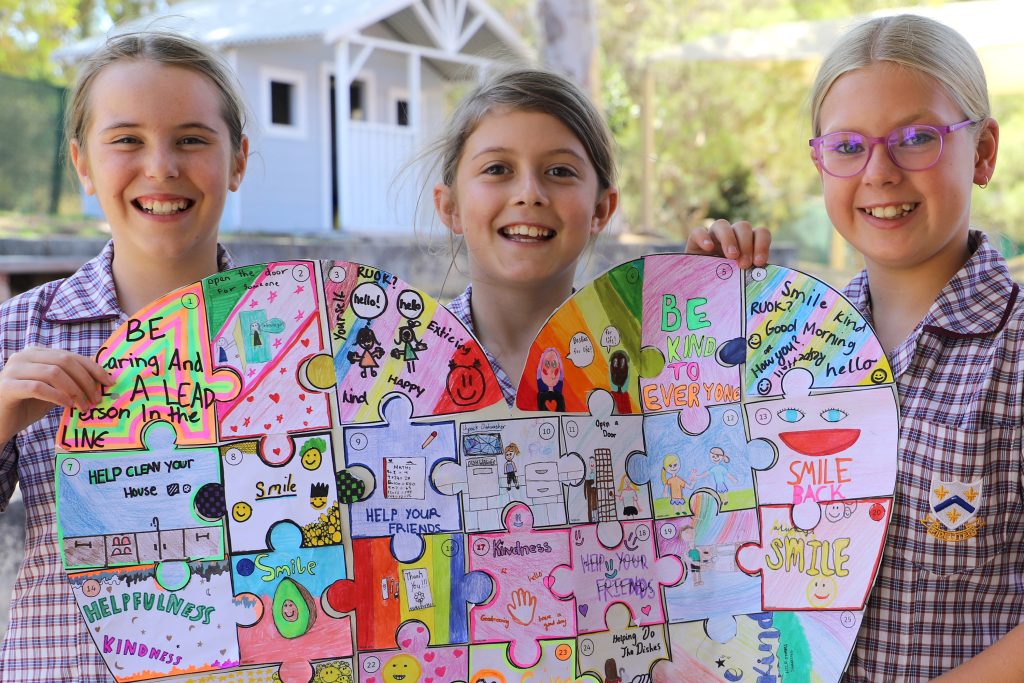 Three girls holding up heart-shaped puzzle at 鶹ƵAV Girl's boarding School Early Learning Centre, fostering potential.